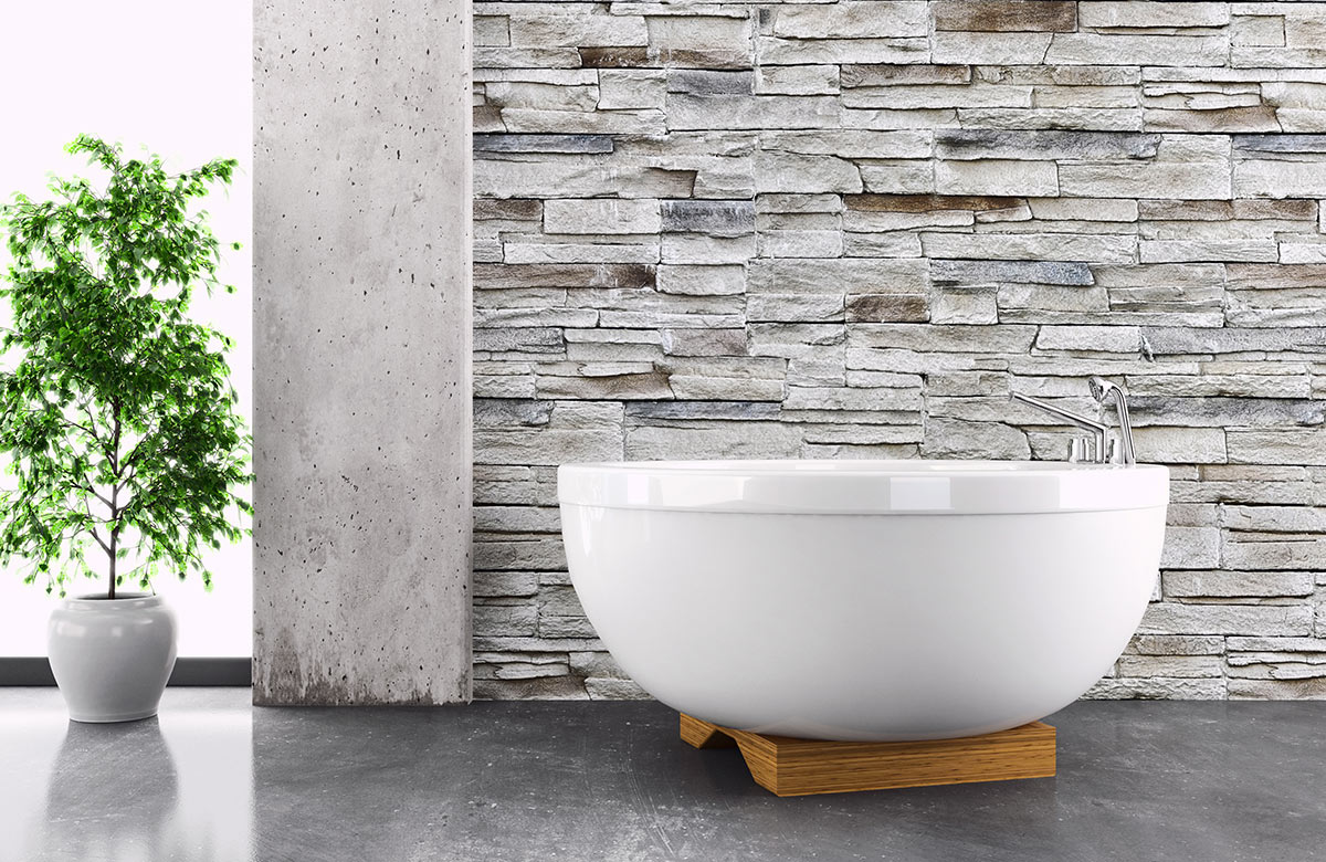 Bagno moderno con vasca tondo bianca e parete rivestita in pietra