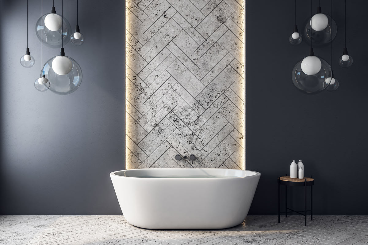 Bagno design con vasca da bagno e parete grigia spezzata con una strisce di piastrelle bianche a spina di pesce.