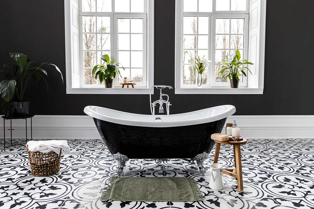 Bagno moderno bianco e nero con piantine sul bordo finestra.