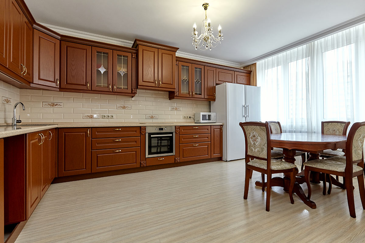 Cucina in legno angolare con mattonelle beige.