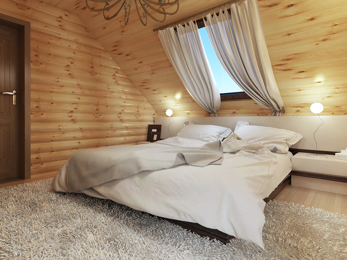Camera da letto in mansarda con pareti in legno.