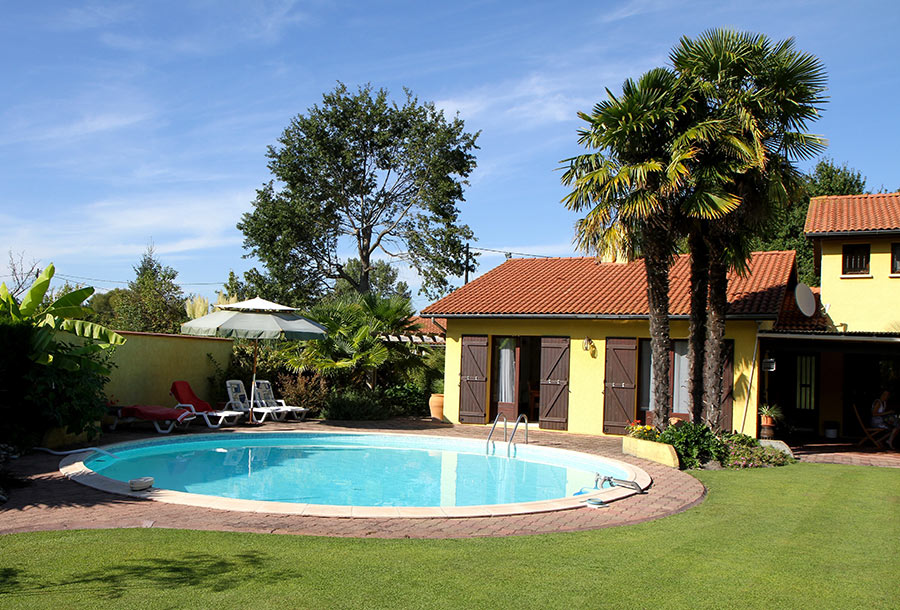 Grande piscina rotonda interrata in acciaio in giardino dietro casa.