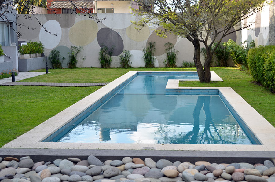 Piscina interrata in muratura con albero in mezzo.