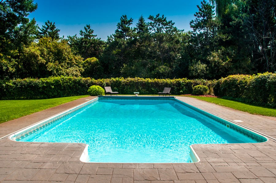 Piscina con struttura in acciaio rettangolare con bordi pavimentato.