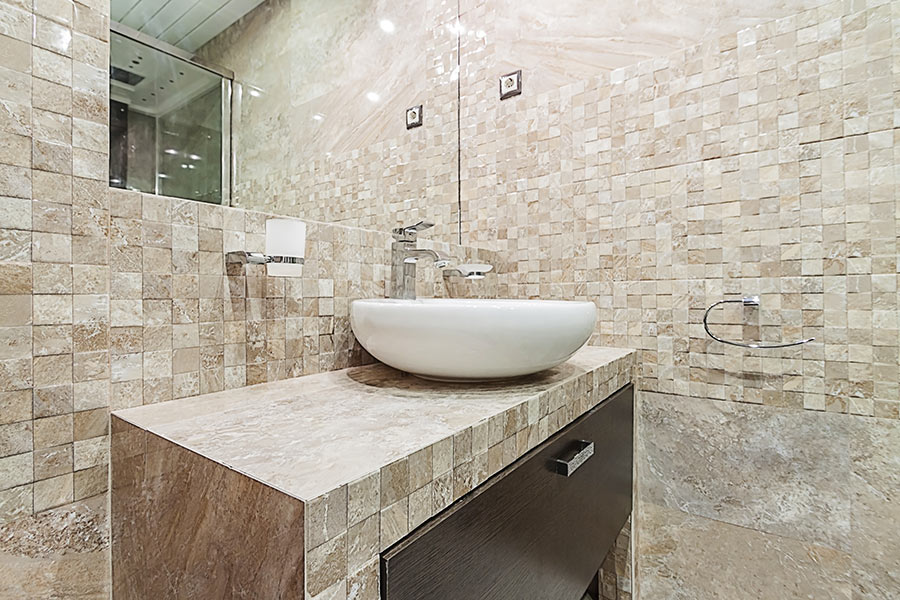 Mobile bagno in muratura con rivestimento in pietra mosaico.