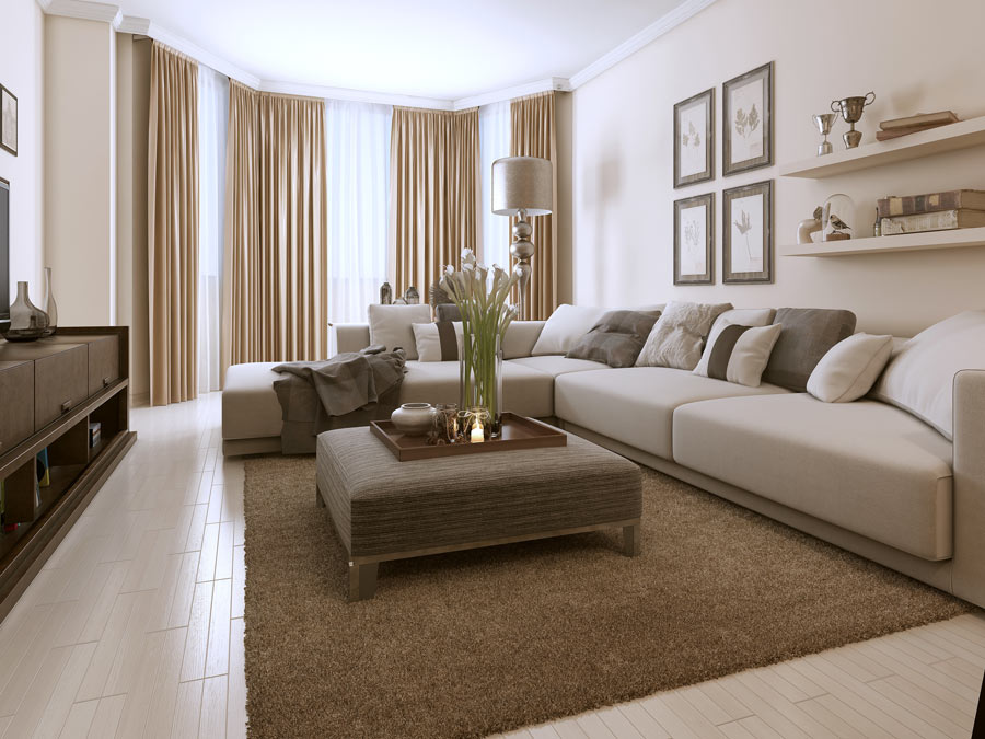 Salotto moderno con pareti e elementi di arredo con sfumature di tortora, grande divano ad angolo beige.
