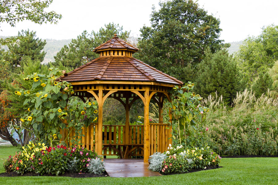 Grande gazebo con pavimento in legno e tetto, ideale per il giardino.