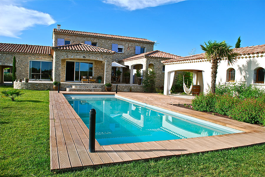 Piscina in giardino con pavimentazione in legno.