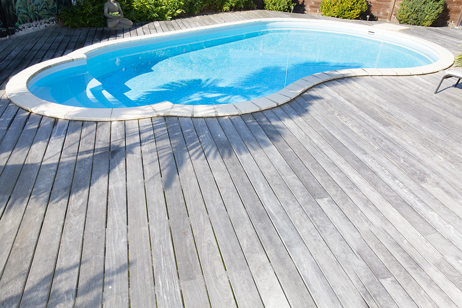 Piscina forma libera con pavimenti in legno.