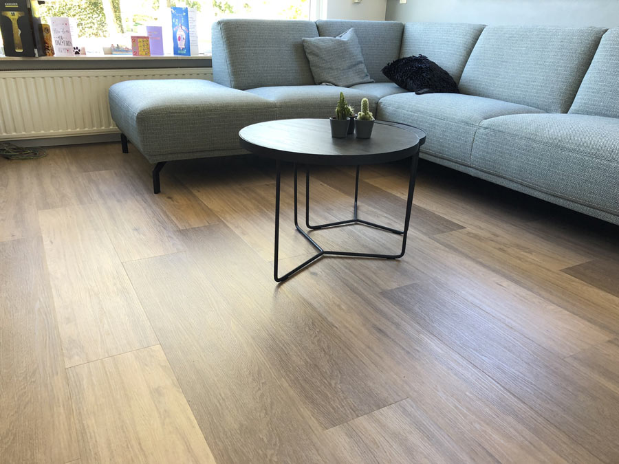 Salotto con pavimento in PVC effetto legno parquet.