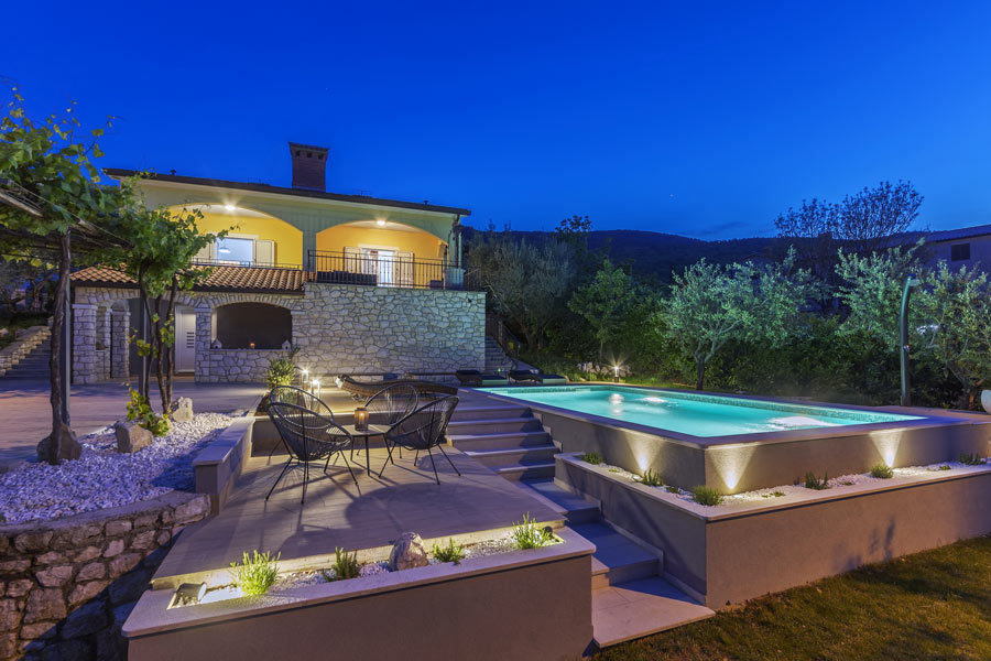 Casa in pietra con grande terrazzo e piscina seminterrata.