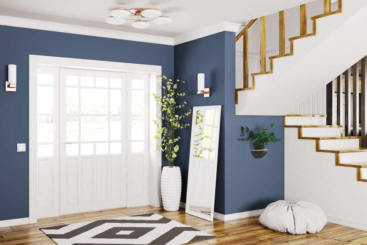 Ingresso di casa accogliente e luminosa con porta bianca e parete blu.