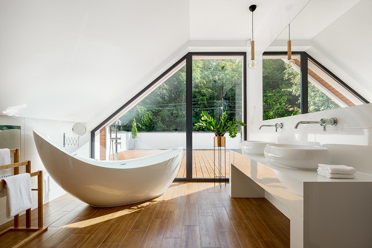 Bellissimo bagno stile moderno con vasca design e pavimento effetto legno.
