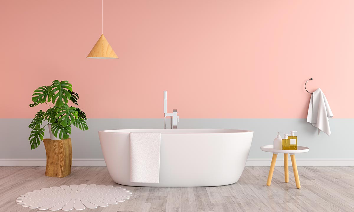 Bagno moderno con parete rosa e grigia con vasca bianca.