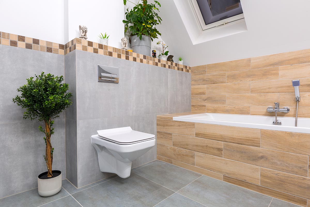 Bagno moderno con parete con piastrelle grigie e vasca rivestito con piastrelle effetto legno.