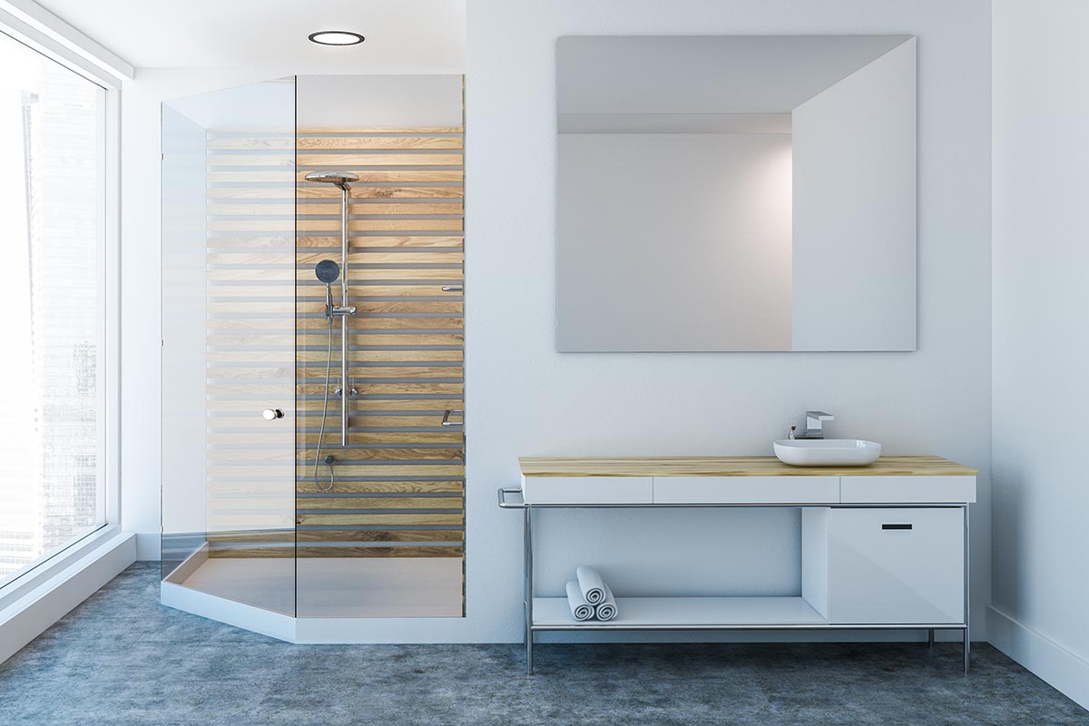 Bagno bianco con doccia angolare e parete in legno.