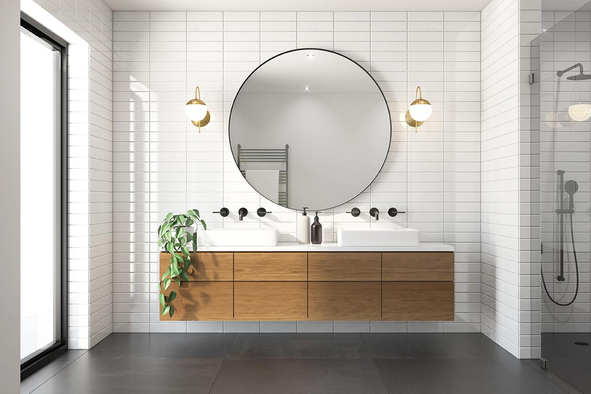 Bagno moderno con mobile lavabo in legno sospeso e grande specchio rotondo.